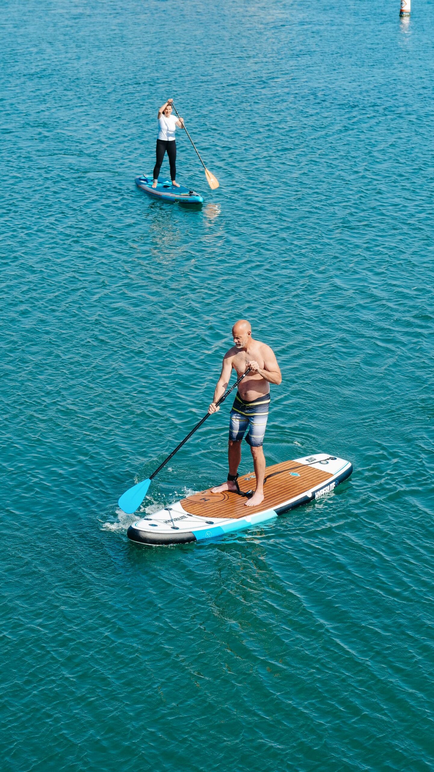Best Inflatable Paddle Boards for Beginners Paddle boarder moving across calm open water