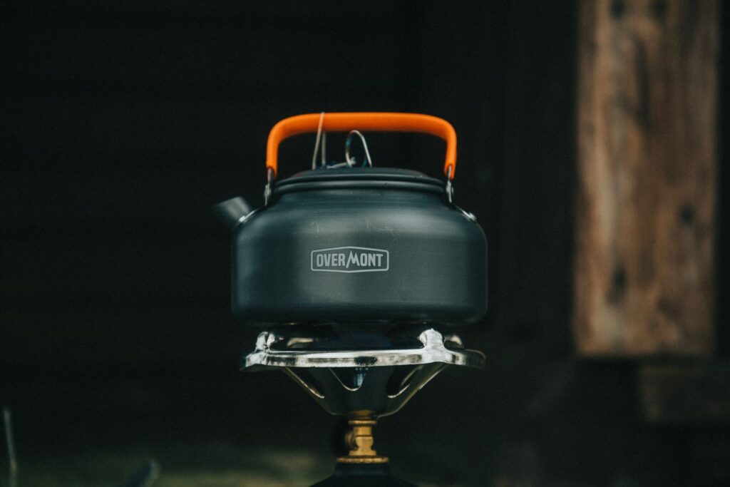Best Two-Burner Camping Stoves for Family Campsites Camping kettle heating on a portable outdoor stove