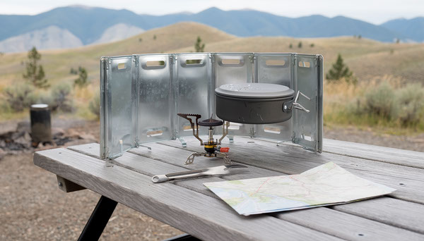 Camping Stove Windscreen: Worth Carrying or Skip It? Camping cook stove with windscreen and pot on table