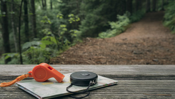 Emergency whistle and personal alarm at a forest trailhead