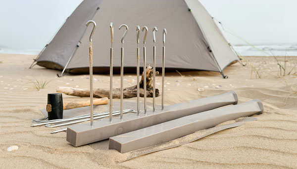 Metal and plastic tent stakes on sand