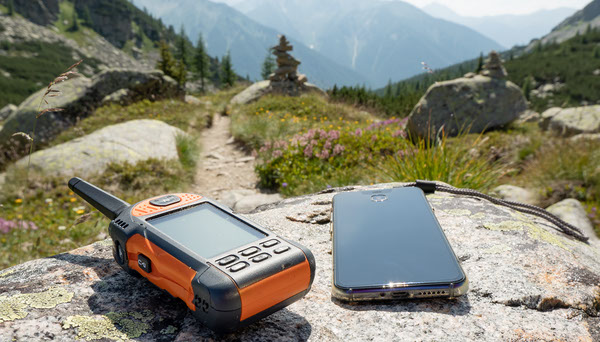 Satellite communicator and smartphone on rock
