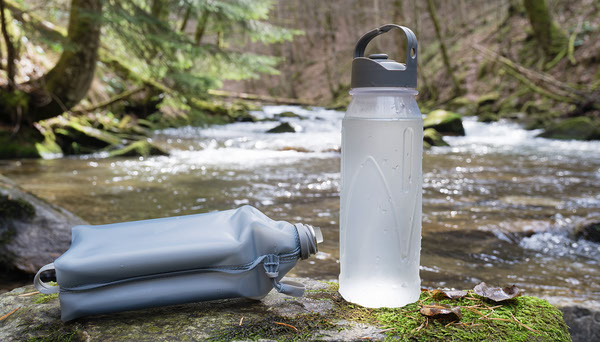 Soft Flask vs Rigid Bottle for Day Hiking: Which Is Better? Soft flask and rigid bottle on streamside trail