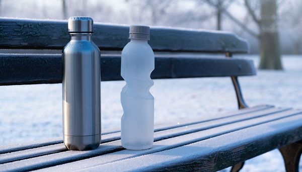 Insulated and standard bottles on a frosty bench